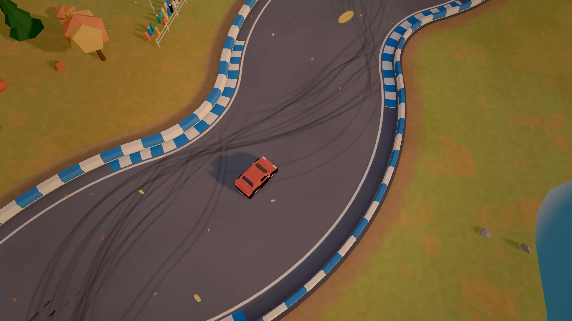 A red car sliding through an S-bend among orange autumn trees, tyre marks all over the asphalt